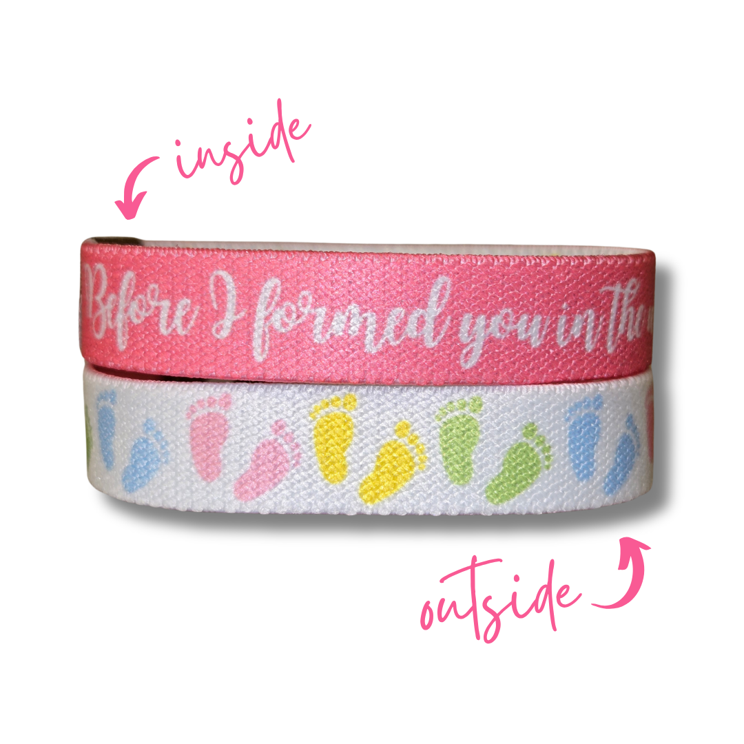 Pro-life Womens TruthBand from Pink Salt Riot- elastic wristband with pastel baby feet on one side and white words on pink background on the other side and arrows pointing to the inside and outside