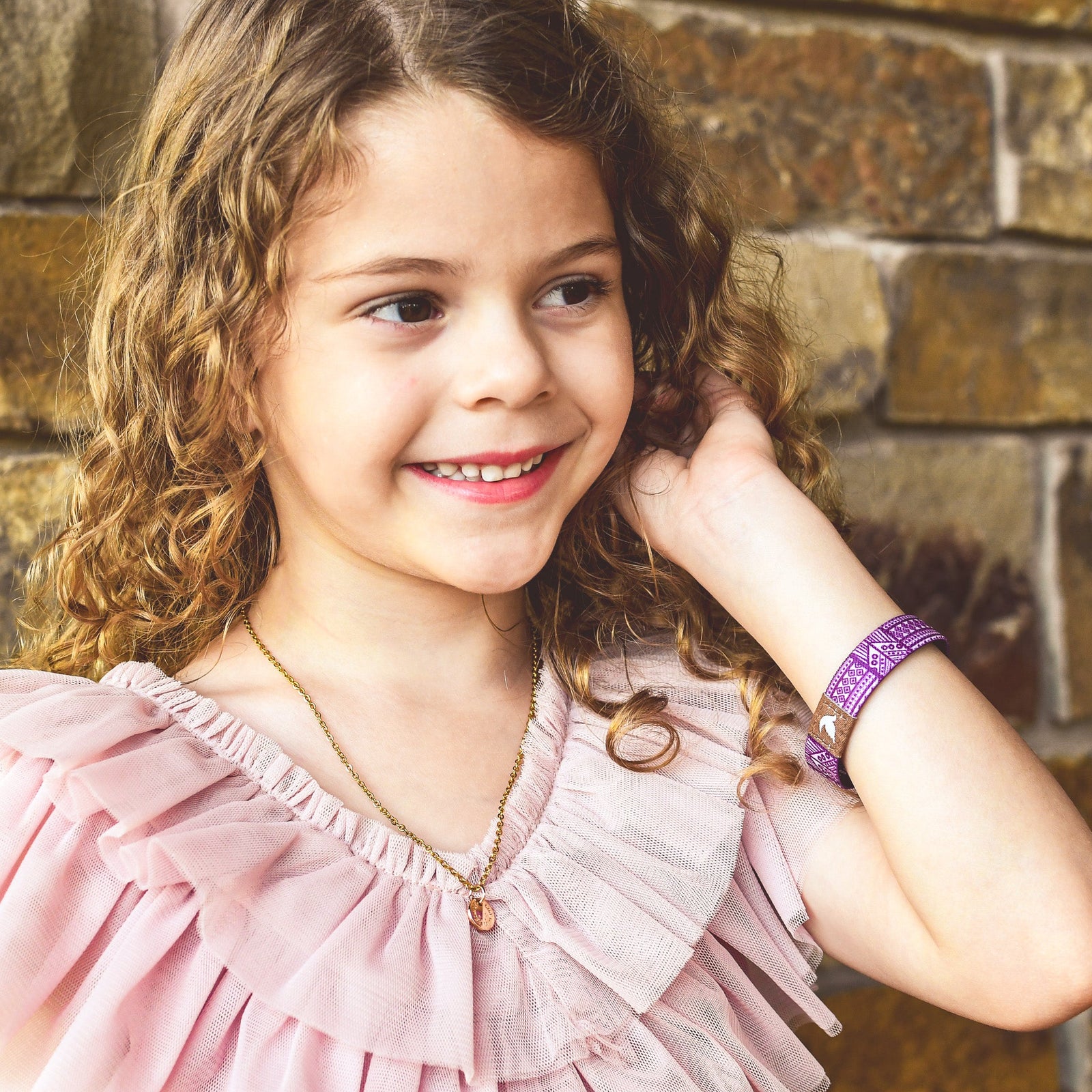 Smiling girl wearing a purple Christian kids bracelet by Pink Salt Riot