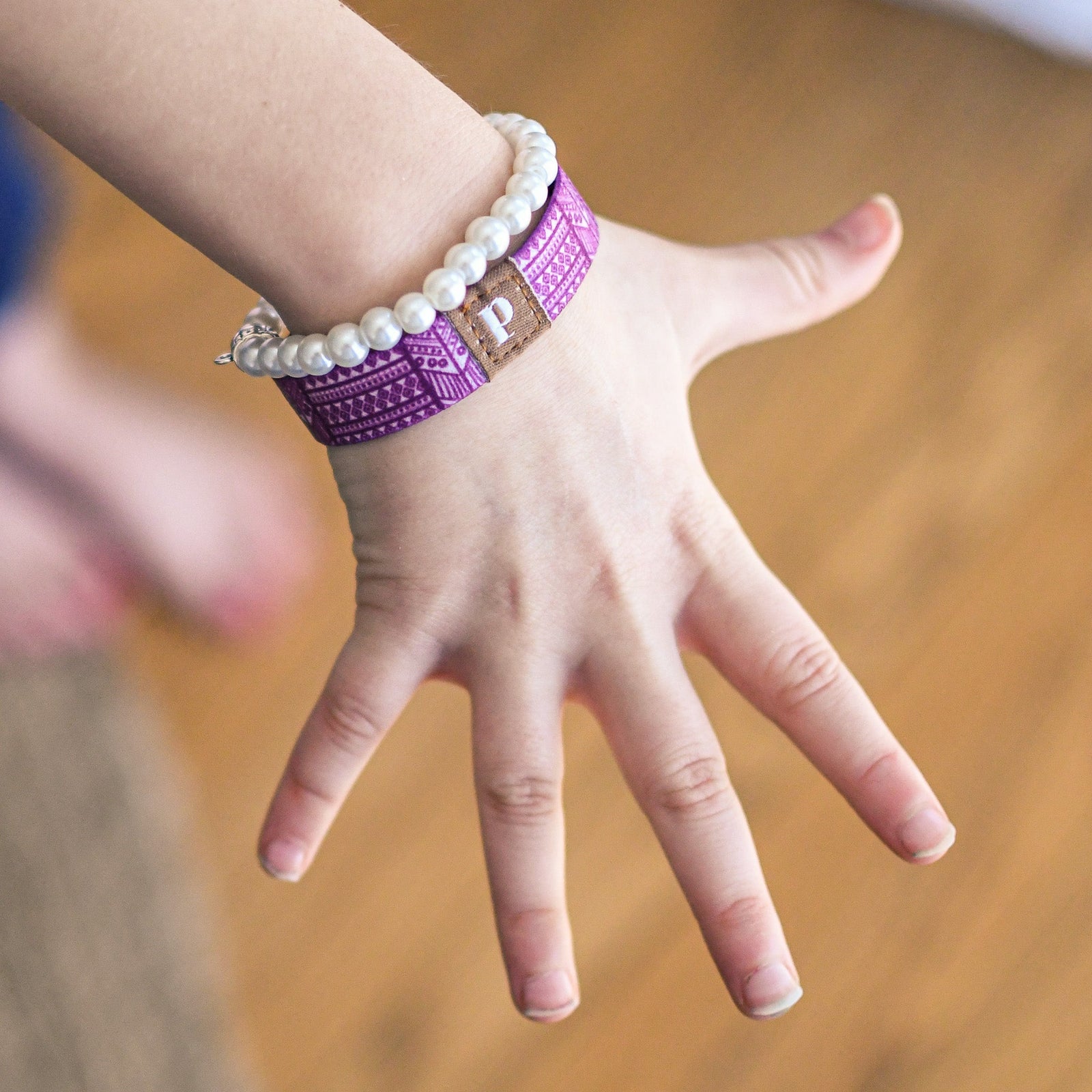 Christian kids bracelet with purple patterned band on child’s wrist