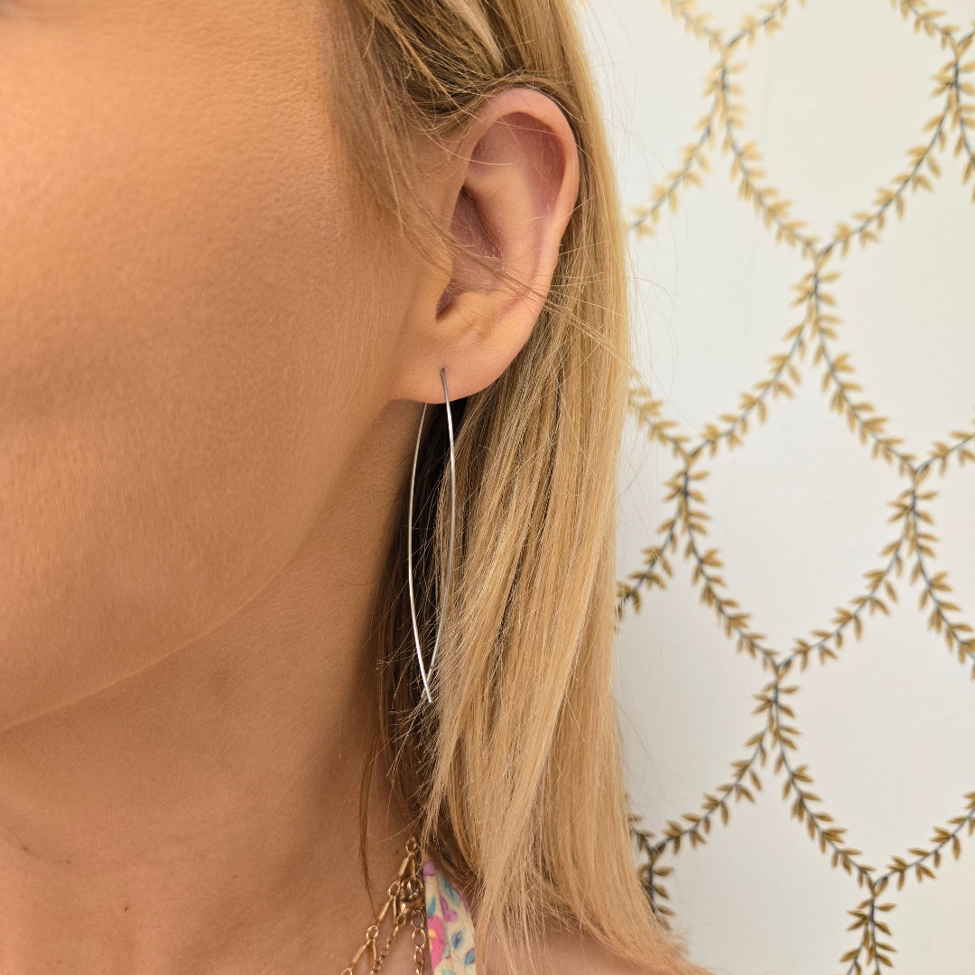 Christian minimalist earrings by Pink Salt Riot worn on a woman's ear with long sleek design